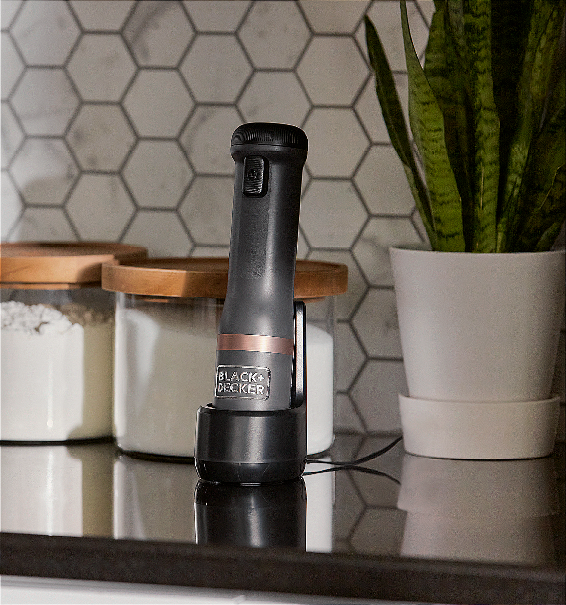 Grey, BLACK+DECKER kitchen wand base sitting in charging dock on the kitchen countertop