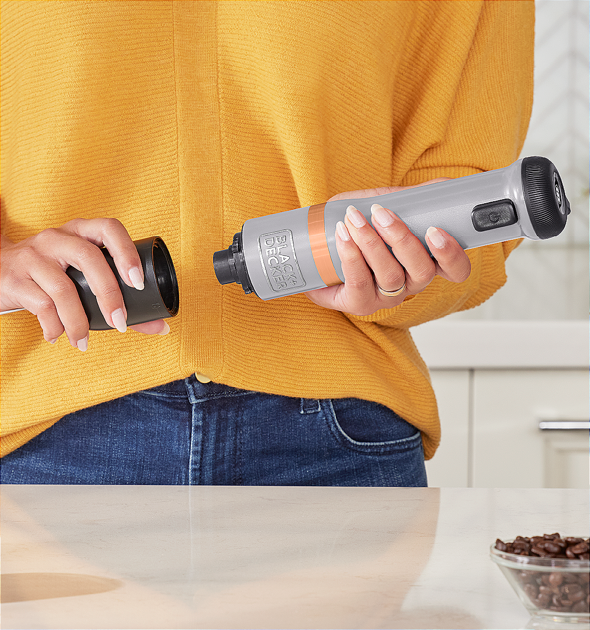 Talent showing how to attach the BLACK+DECKER kitchen wand milk frother attachment to the grey power unit