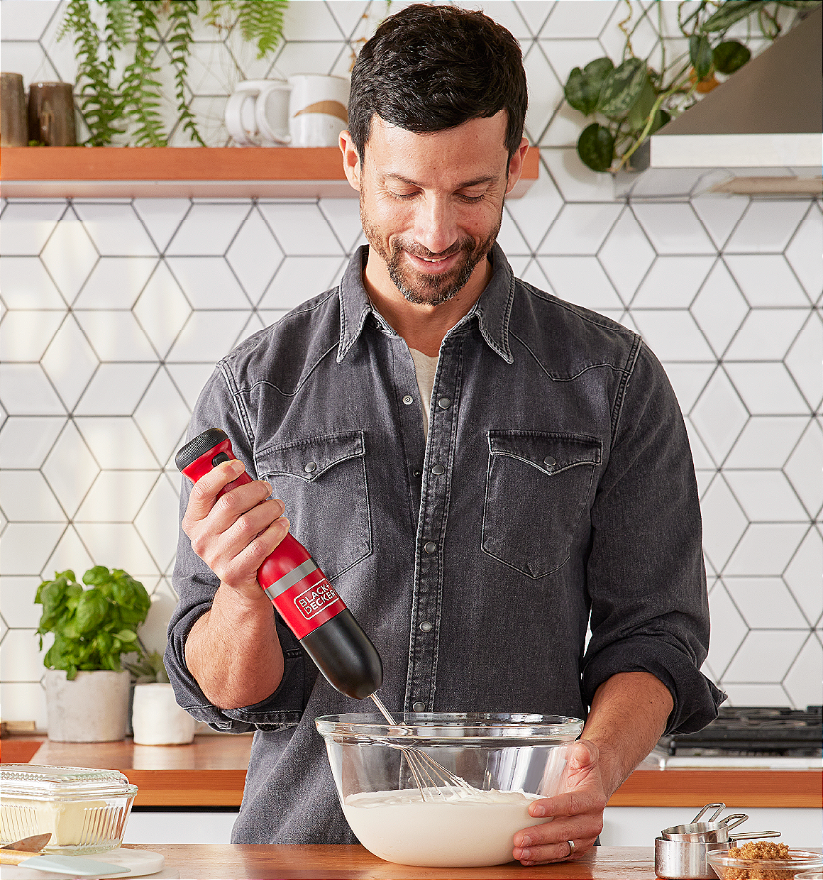 Talent using the red, BLACK+DECKER kitchen wand whisk to make whipped cream