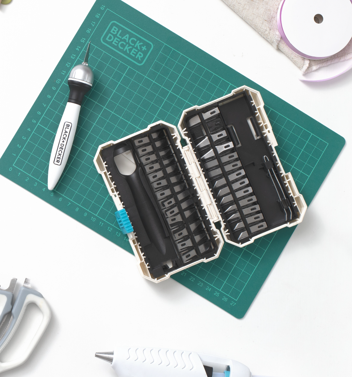lay down image of manual crafting tools from the BLACK+DECKER Crafting Collection mixed with various crafting materials and supplies