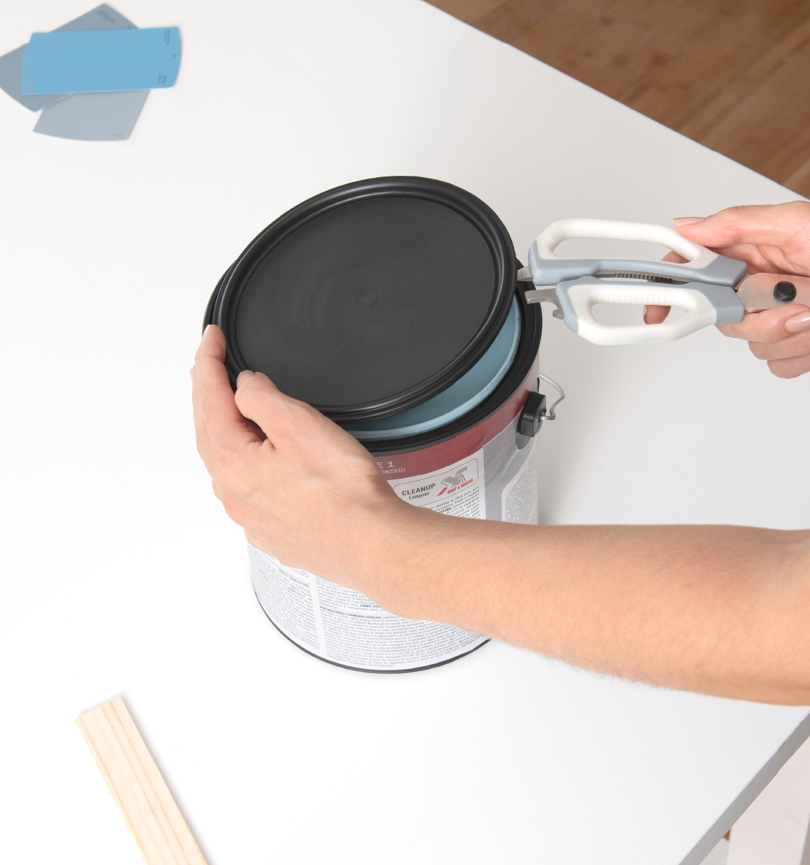 a close up of the paint can opener on the handle of BLACK+DECKER crafting shears being used to open a paint can