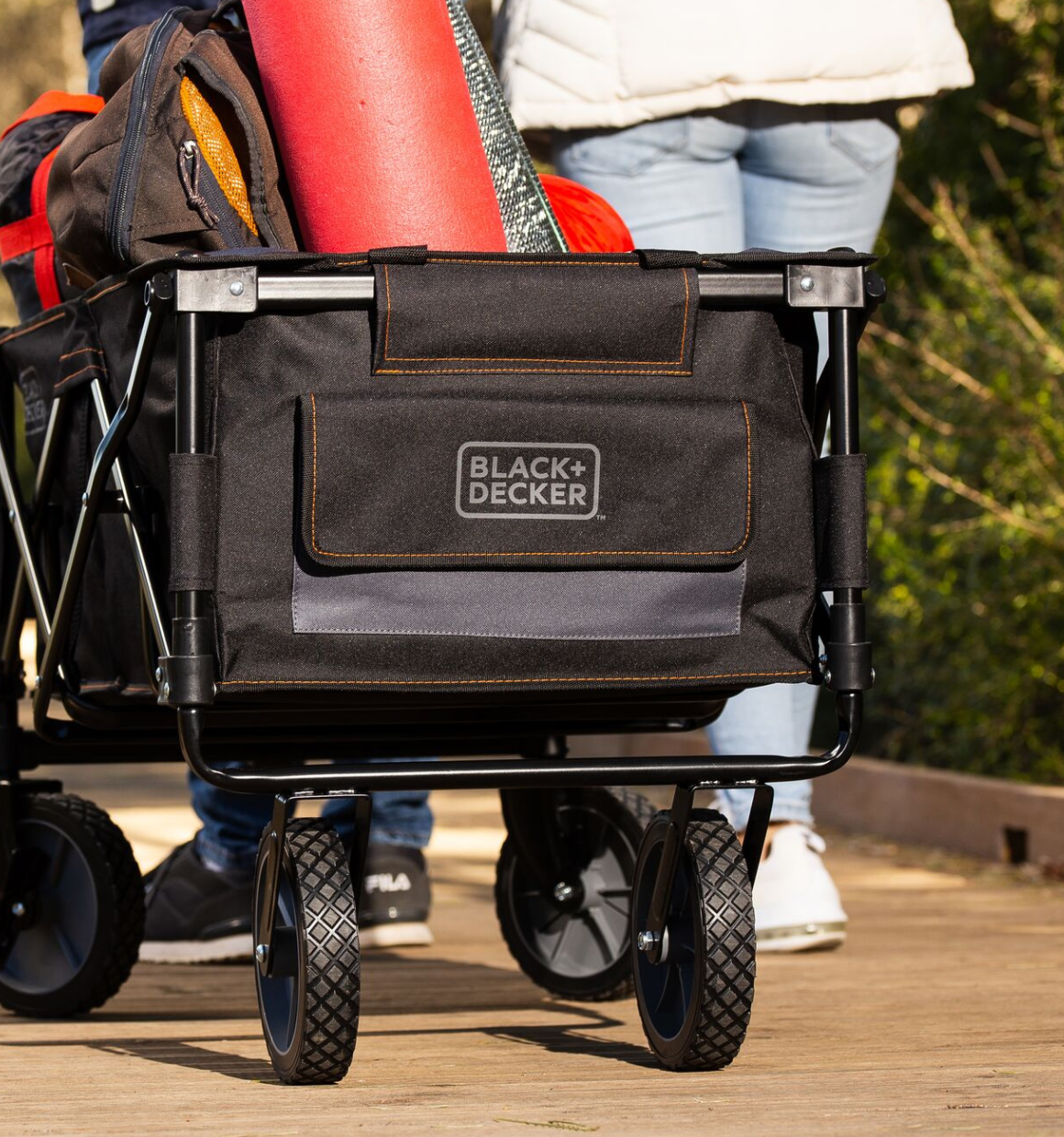 Person pulling the utility wagon, collapsible/folding wagon filled with soccer equipment