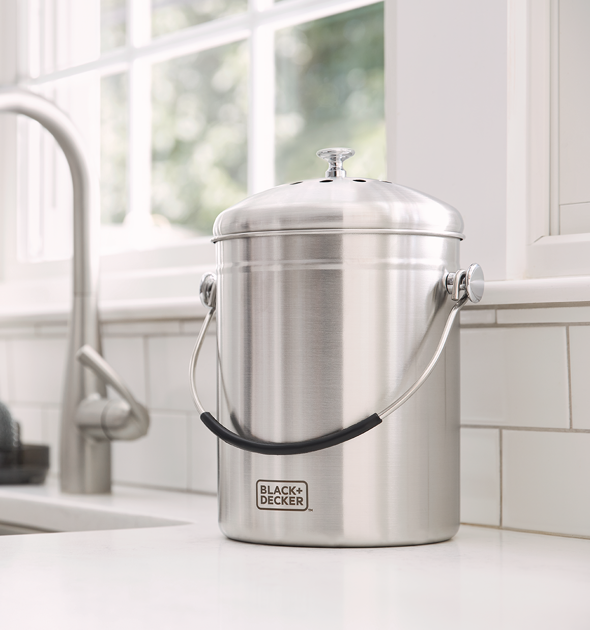 Stainless Steel Countertop Compost Bin sitting on a kitchen countertop.