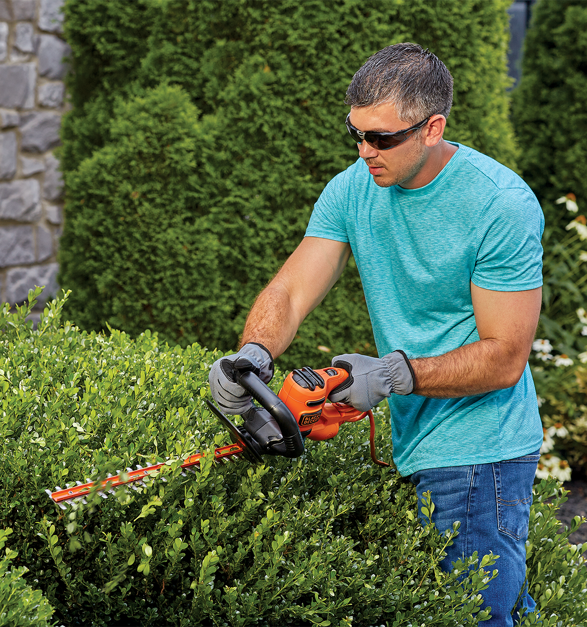 18 inch Electric hedge trimmer being used by a person to trim bushes.