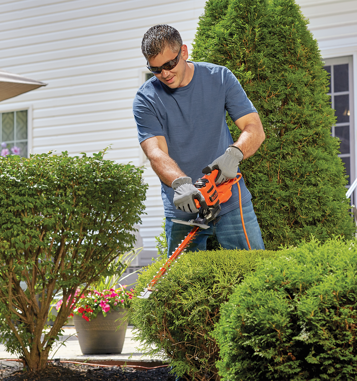 16 inch saw blade electric hedge trimmer being used by a person.
