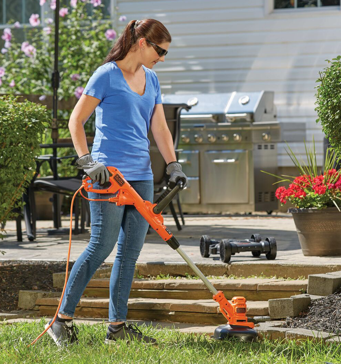 12 inch Electric string trimmer being used by person to trim grass.