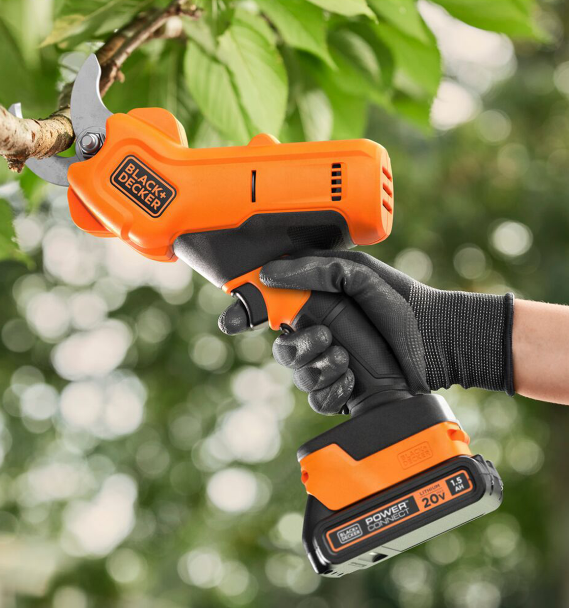 Cordless 20 volt max Black and Decker trimmer being used to cut a tree branch, powered by a black and decker 20 volt lithium battery.