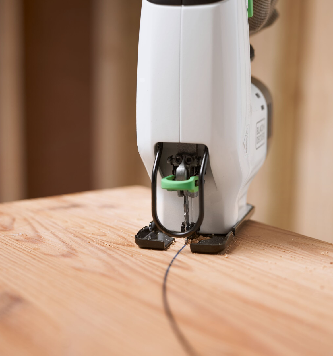 Close-up of a Reviva 12V Jigsaw sawing a circular pattern in a sheet of wood.