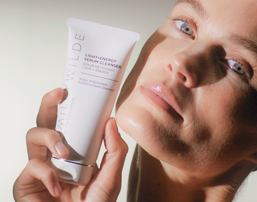 Woman Holding Serum Cleanser By Her Face