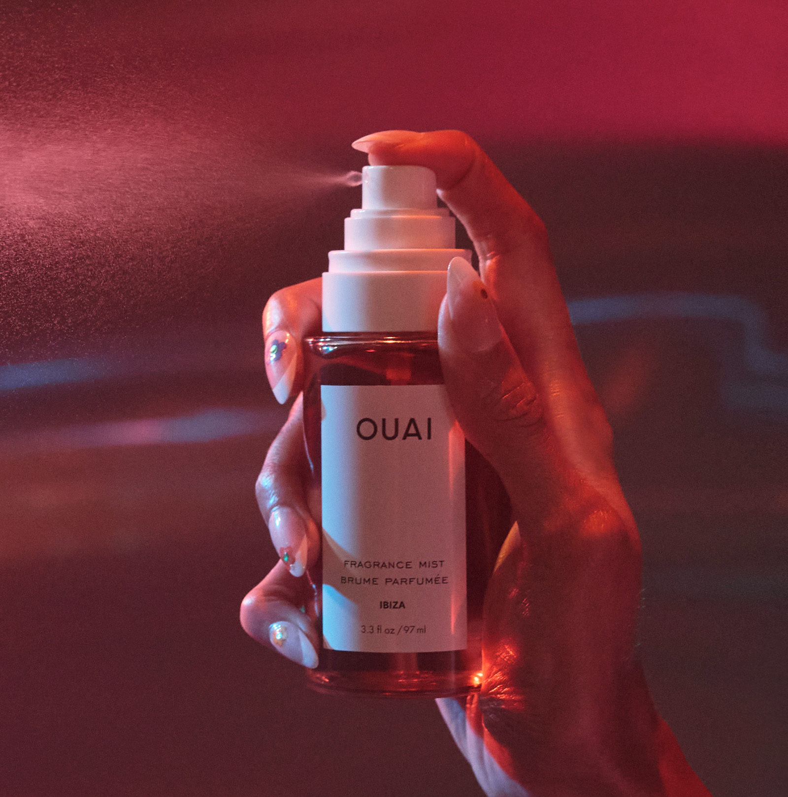 Model spraying Ibiza scented hair and body fragrance mist bottle