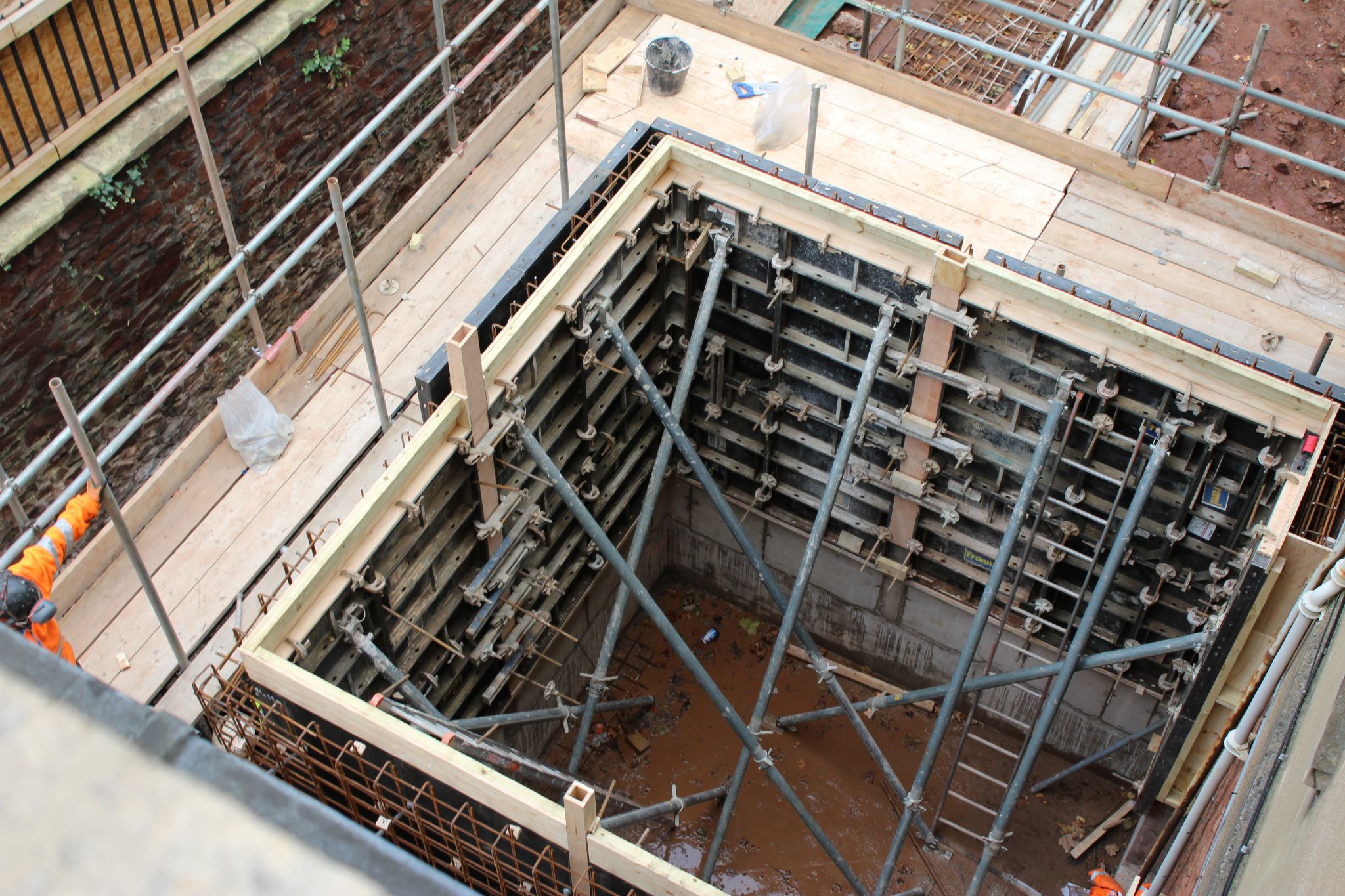 A view looking downwards into building works with scaffolding and timber frame 