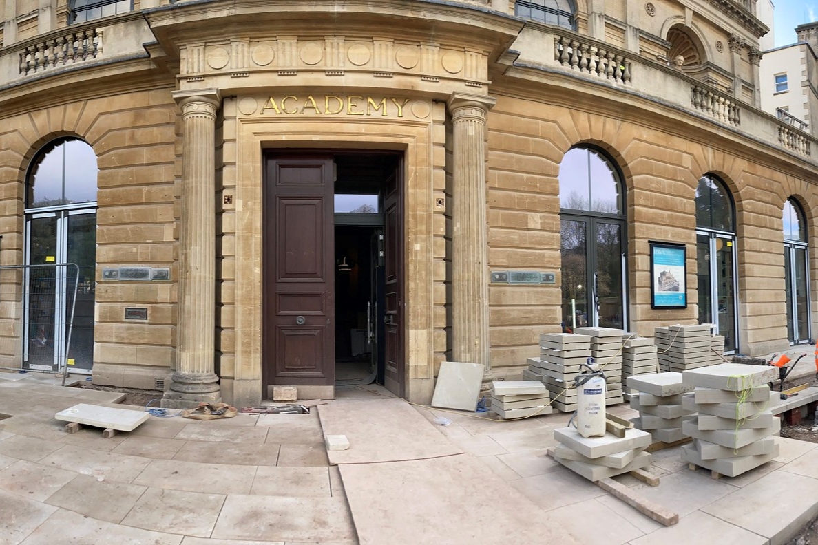 The front of a building with the word Academy above the door 