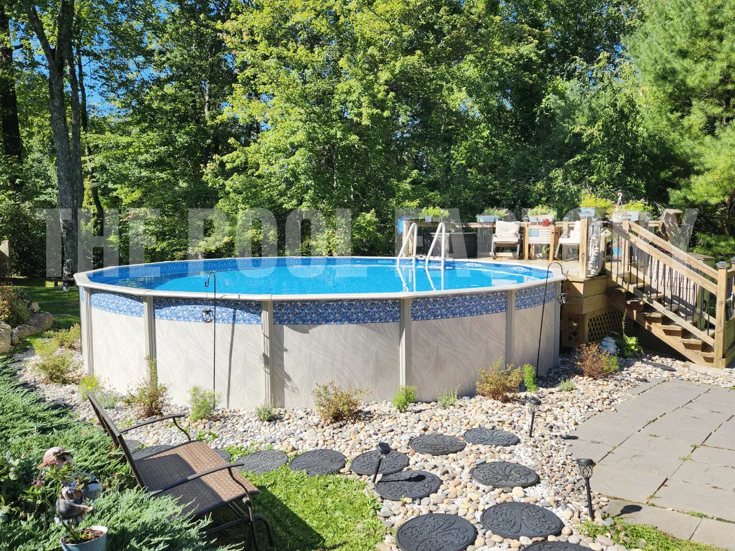 Round above ground pool with a partial wooden deck and cushioned chairs
