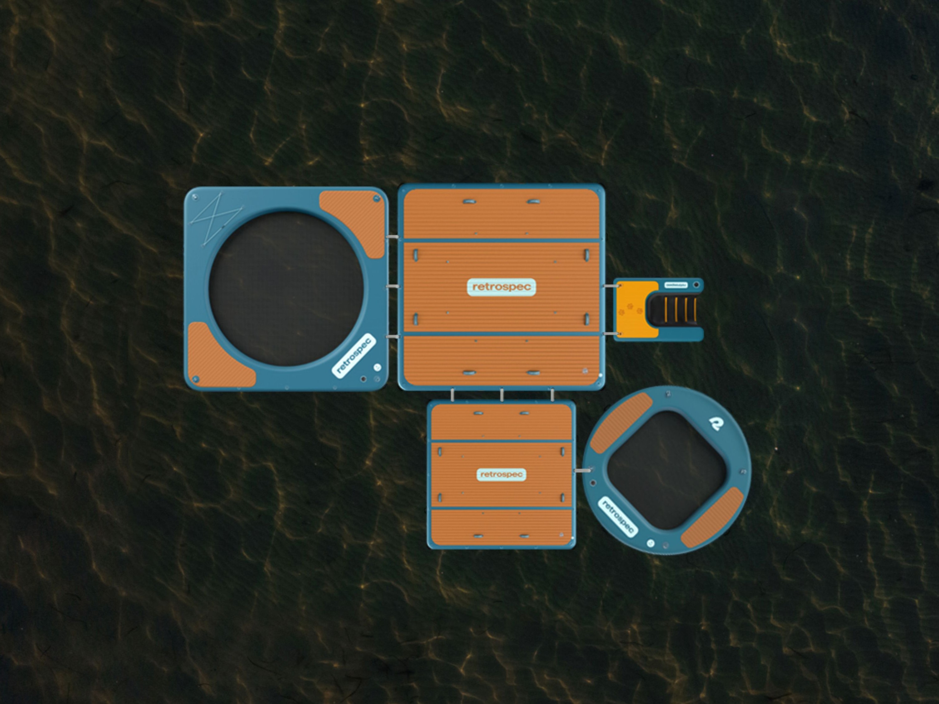 Aerial view of the Siesta floating platforms and hammocks on water, featuring circular and square sections with orange surfaces and interconnected design.