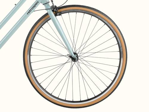 Close-up of a bicycle's front wheel, tire and part of the frame on a white background.