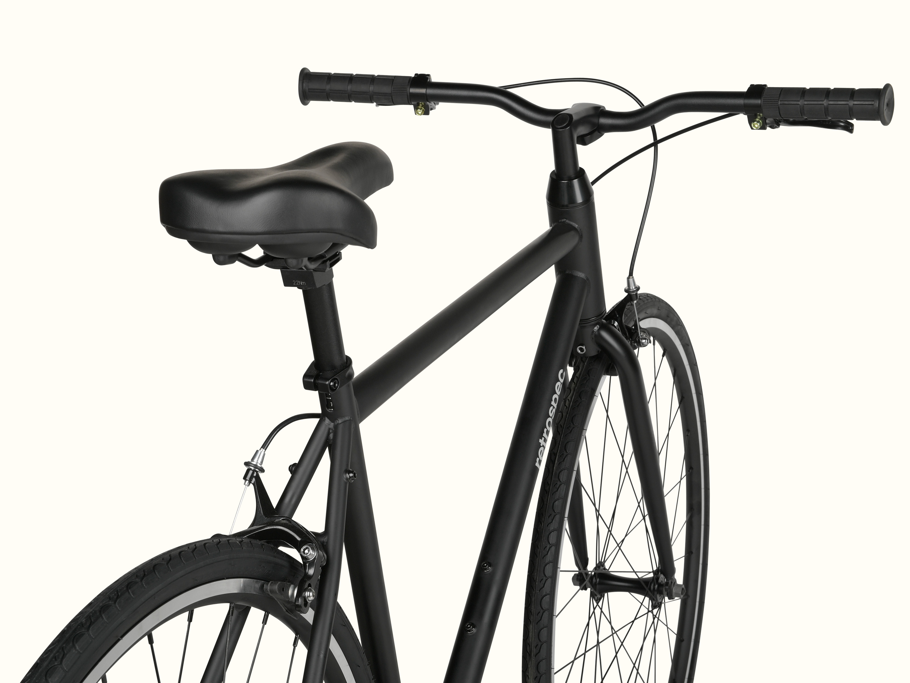 Black bicycle with a focus on the saddle and handlebars against a white background.