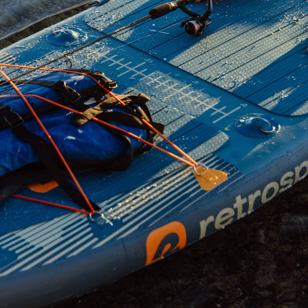 A close-up of the bungee storage area of the June Fishing Paddle Board Kayak Hybrid with a built-in ruler for measuring fish.