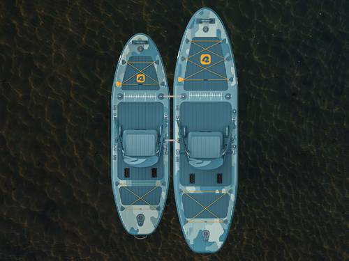 A June and June Nano Inflatable Fishing Paddle Board Kayak Hybrids attached with tether straps and viewed from above, floating in clear water with gentle ripples.