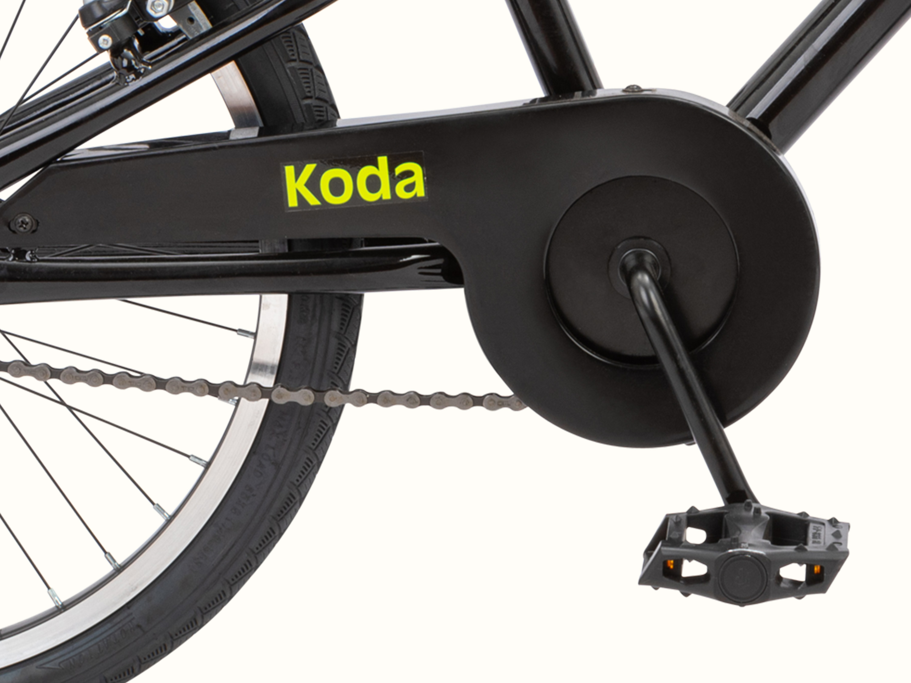 Close-up of a black bike's rear wheel, chain, and pedal, with the name 