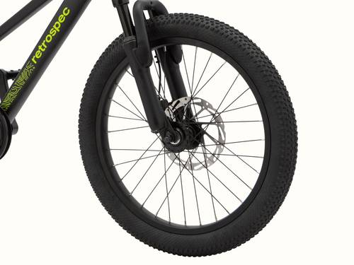 Close-up of the Koda Plus 20" Kids' Matte Black Mamba Bicycle's front wheel with disc brake and part of the frame visible displaying "retrospec" in neon green.