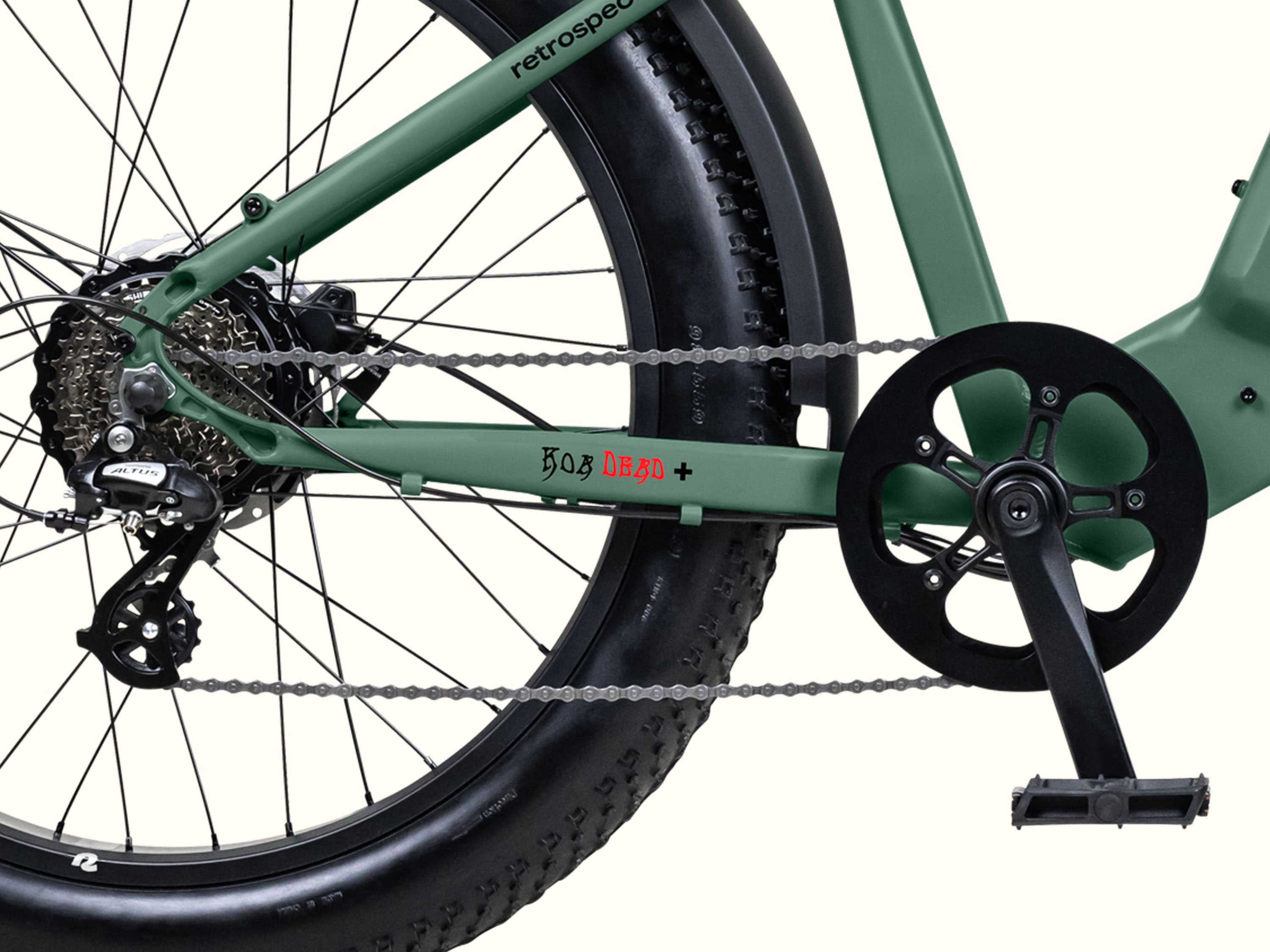 Close-up of the Grateful Dead Koa Rev+ Electric Fat Tire Bike's drivetrain, showcasing the chain, rear derailleur, and crankset, with 