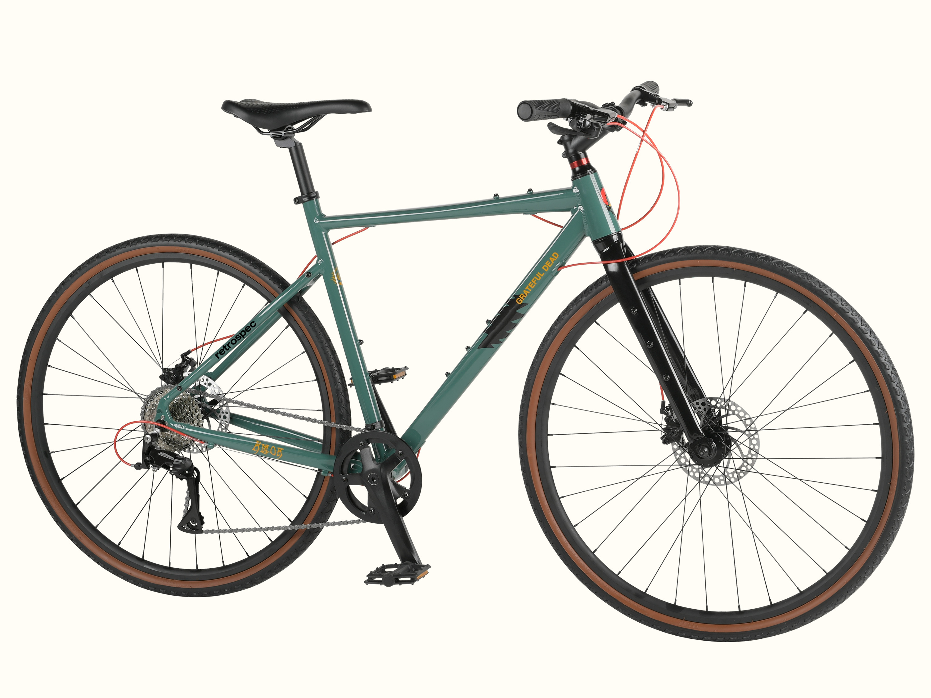 The green and black Grateful Dead Amok 8 Speed Gravel Adventure Bike with brown tires, featuring disc brakes, a comfortable saddle, and a modern design with Grateful Dead iconic artwork such as 