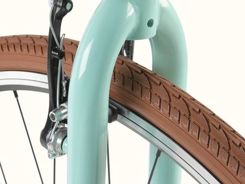 Close-up of the Grateful Dead Kinney Mixte 7 Speed City Bicycle's front fork in mint green, showcasing a brown tire with textured tread and black brake components.