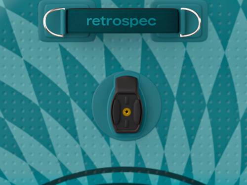 Close-up of a turquoise surface featuring a black valve with a yellow center, set against a patterned background.