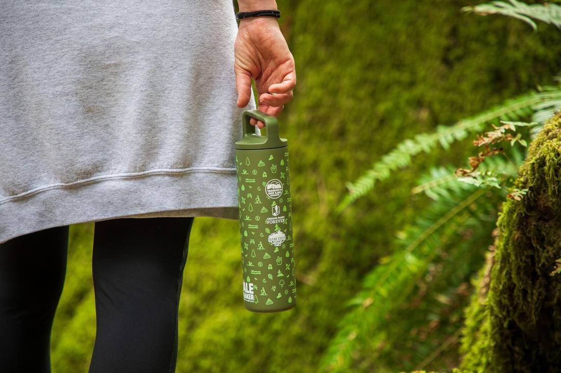 Person carrying MiiR x Bale Breaker Bottle by handle on trail.