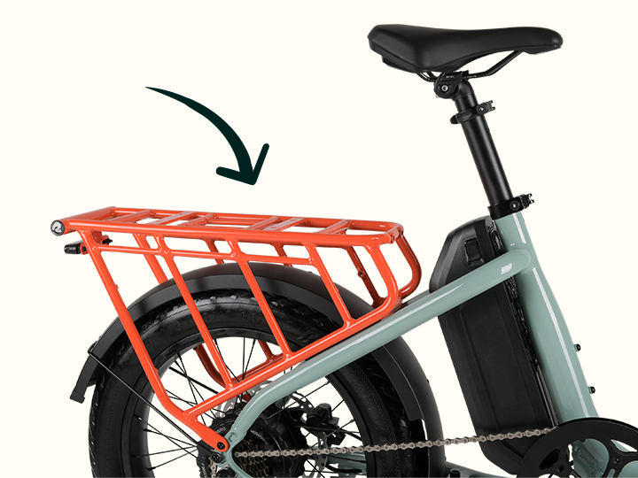 Close-up of the rear of a mint green electric cargo bike with a black drawn arrow pointing to the attached orange rear rack.