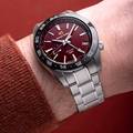Grand Seiko SBGE305 Spring Drive GMT with red dial and black ceramic bezel.