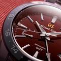 Grand Seiko SBGE305 Spring Drive GMT with red dial and black ceramic bezel.