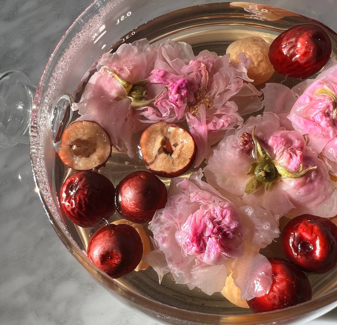 Chinese medicine tea elixir for better sleep and radiant skin with jujube, rose buds and flowers, and longans.