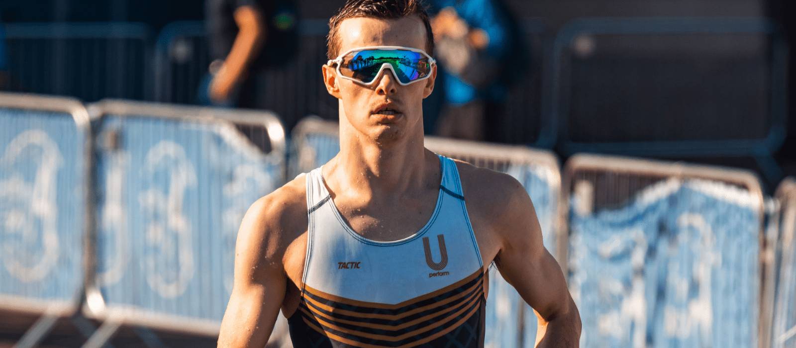 Man in triathlon clothing and sports sunglasses running - U Perform Triathlon
