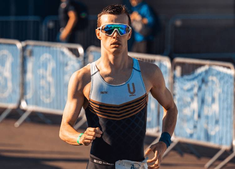 Man in triathlon clothing and sports sunglasses running - U Perform Triathlon