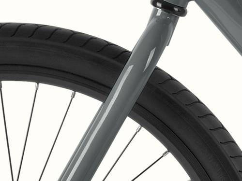 Close-up of a black bicycle tire with tread pattern and a gray Montauk bike fork against a plain background.