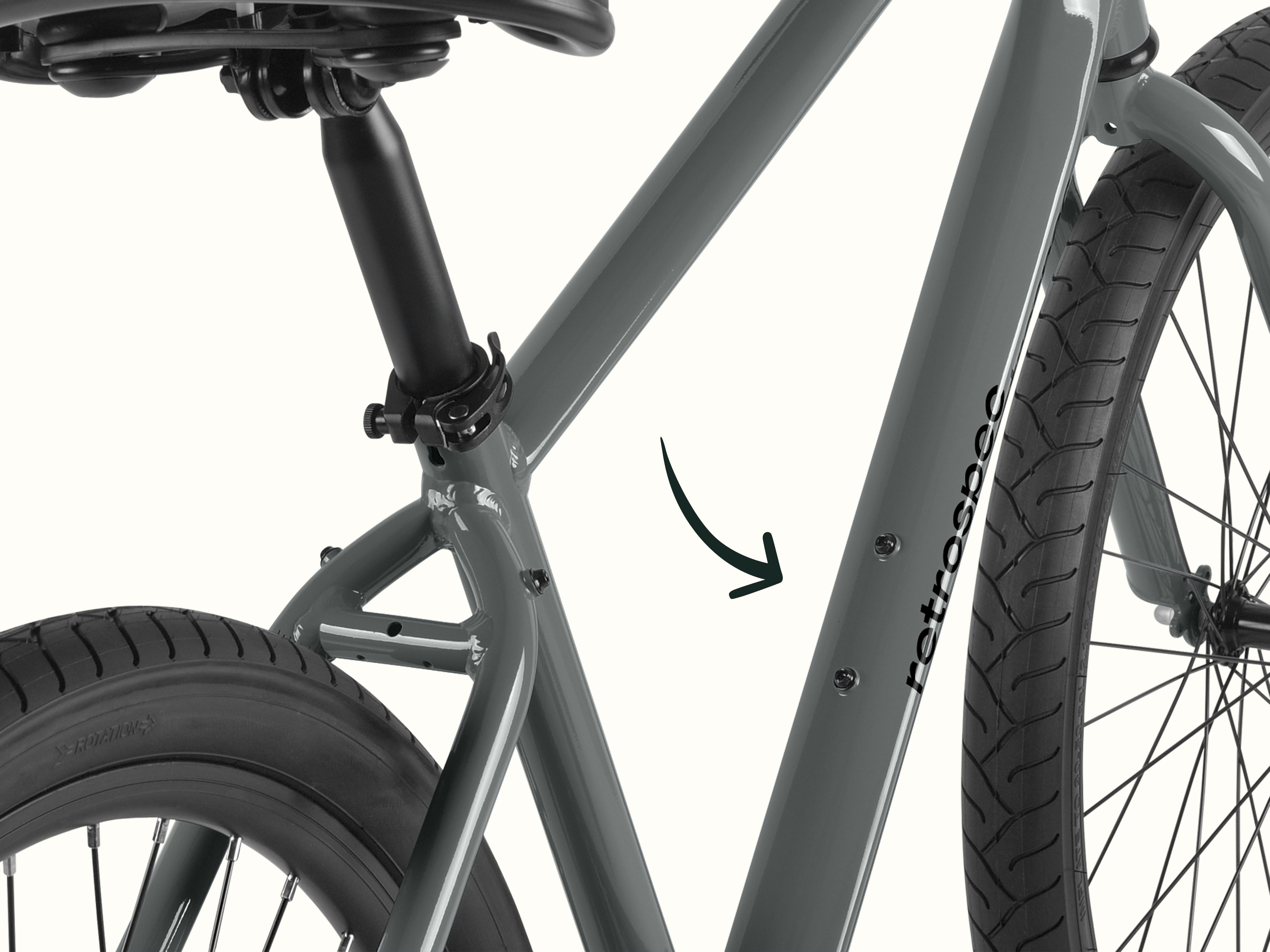 Close-up of a gray retrospec bicycle frame focusing on the seat tube, rear tire, and part of the front tire.
