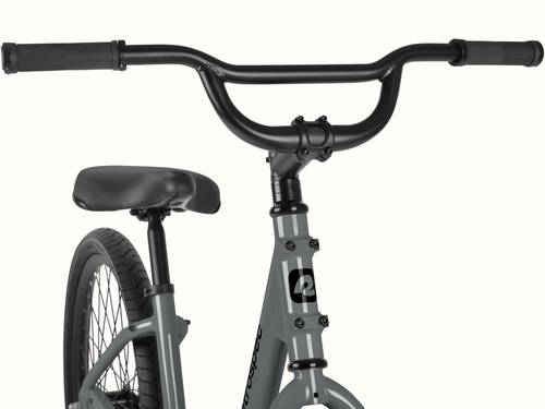 Close-up of the retrospec Montauk step through's wide, BMX-style black handlebars with textured grips, paired with a sturdy stem and the retrospec head tube badge in Graphite.