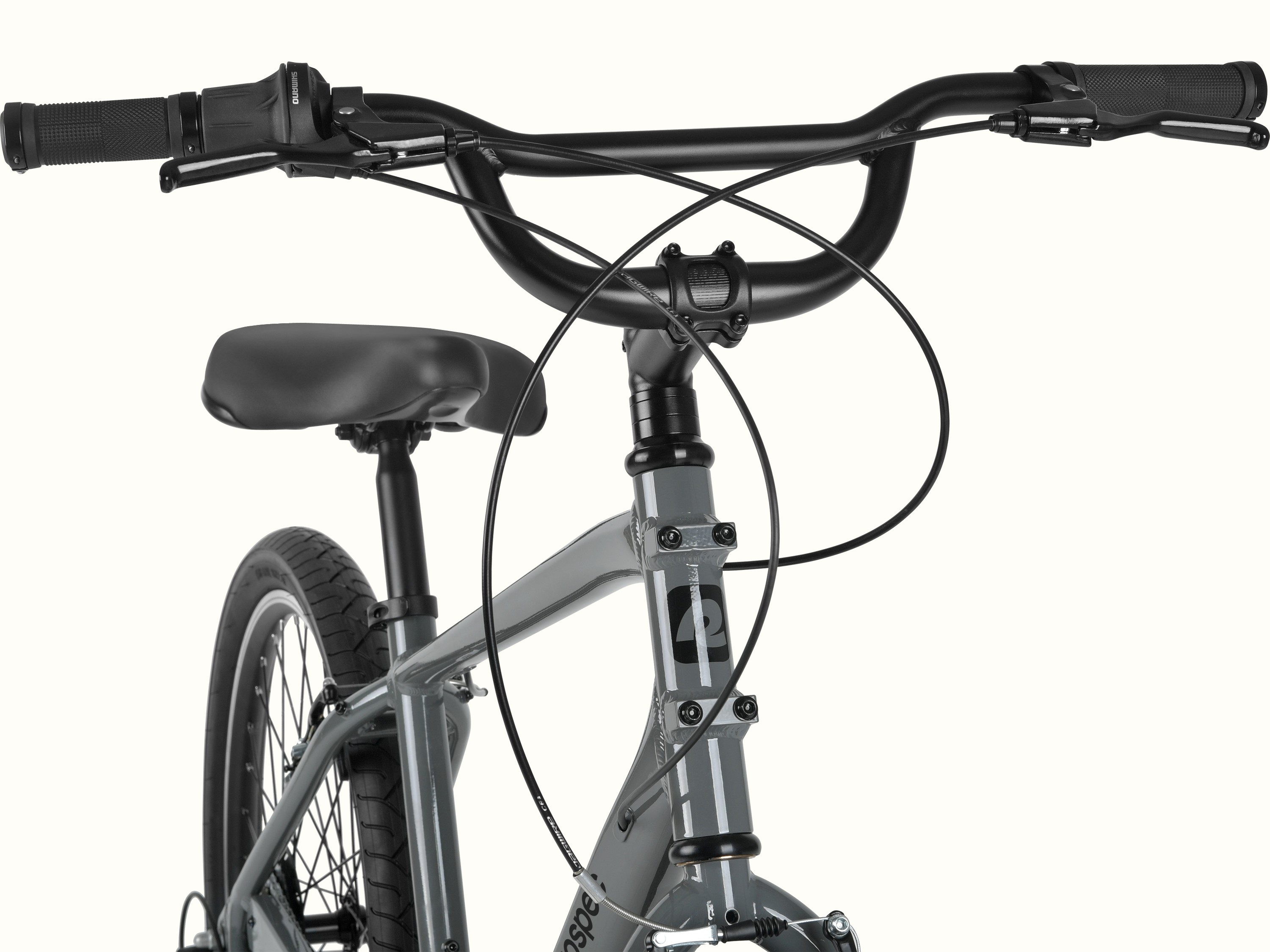 Retrospec Montauk 26 handlebar detail featuring Shimano twist shifters, ergonomic grips, and a wide swept-back bar for a relaxed, upright ride.