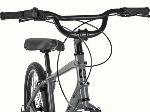 Retrospec Montauk 26 handlebar detail featuring Shimano twist shifters, ergonomic grips, and a wide swept-back bar for a relaxed, upright ride.