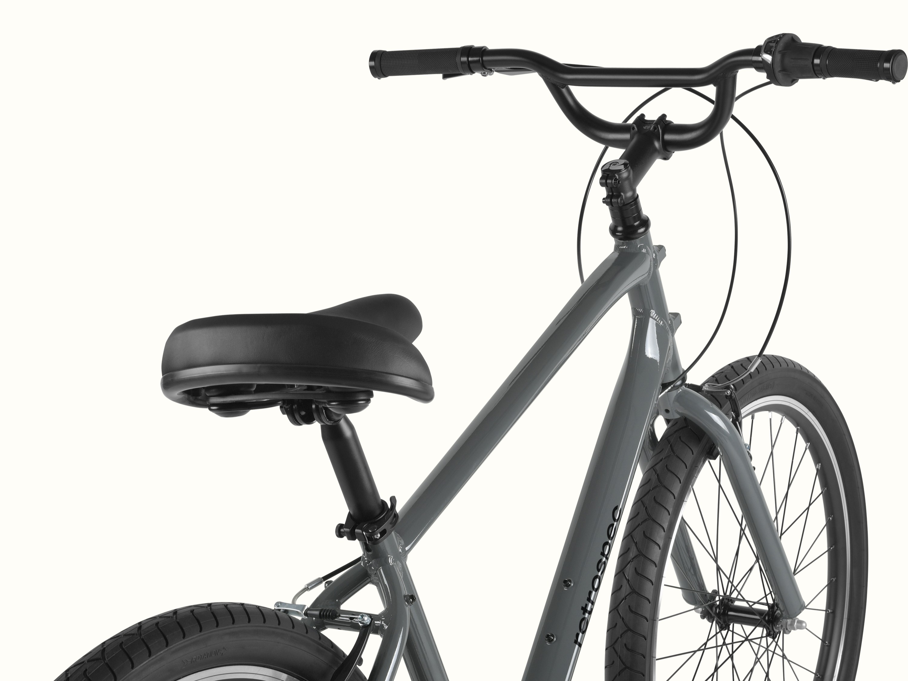 retrospec Montauk 26 comfort bike in Graphite, close-up of the cushioned saddle, swept-back black handlebar, and upright riding position against a clean background.