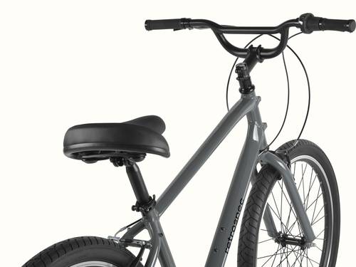 retrospec Montauk 26 comfort bike in Graphite, close-up of the cushioned saddle, swept-back black handlebar, and upright riding position against a clean background.