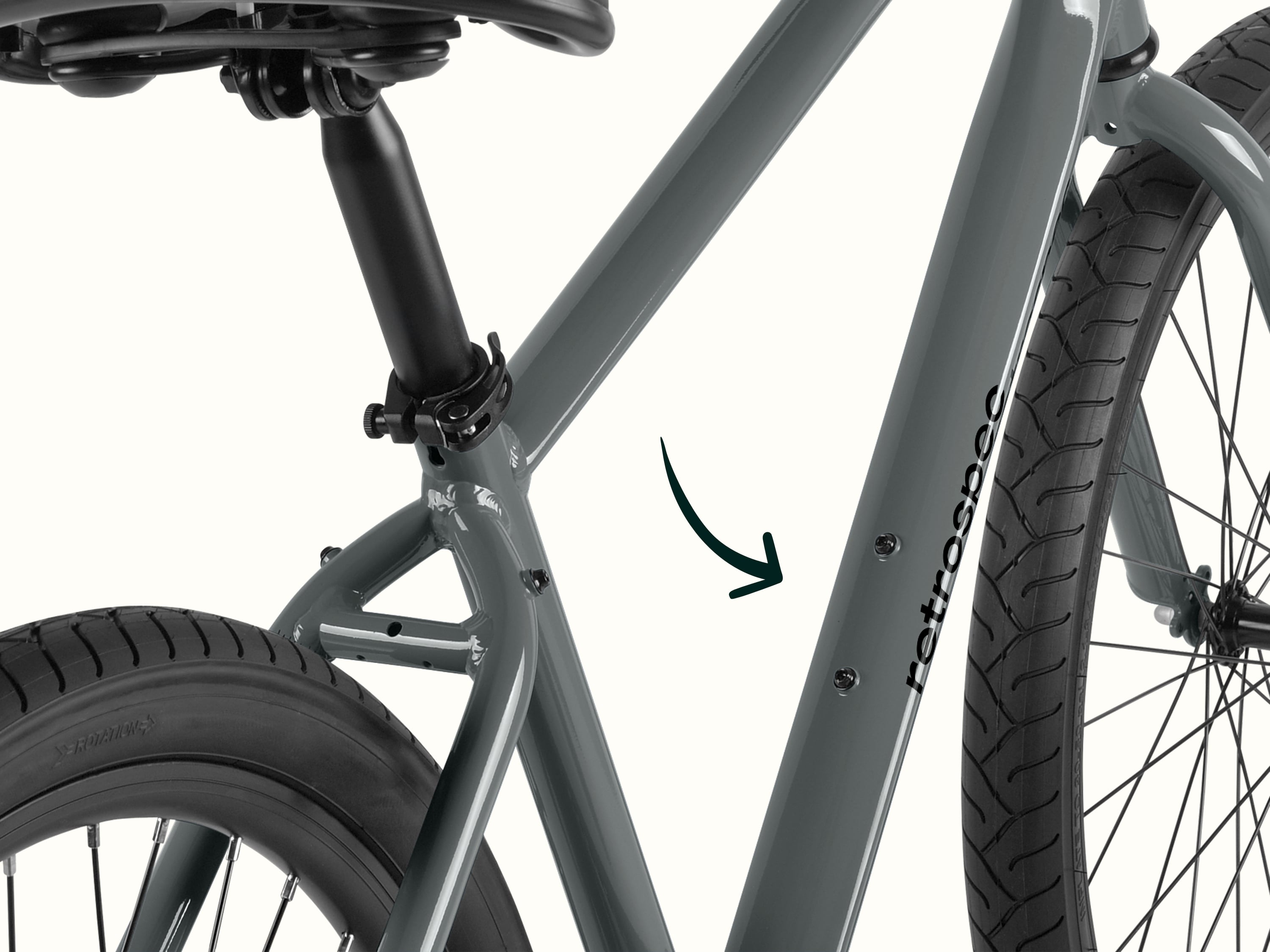Close-up of a gray retrospec bicycle frame focusing on the seat tube, rear tire, and part of the front tire.