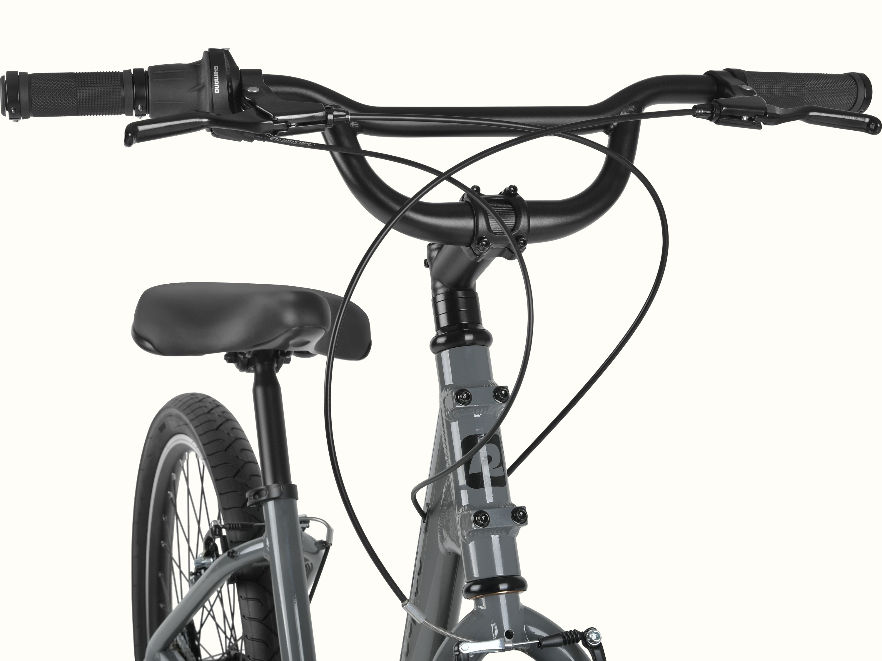 retrospec Montauk 26 handlebar detail featuring Shimano twist shifters, ergonomic grips, and a wide swept-back bar for a relaxed, upright ride.