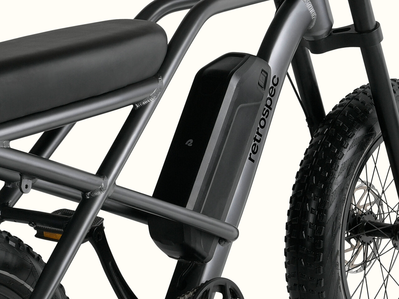 Close-up of the sleek Valen Rev 3 Fat Tire Electric Bike frame featuring a black seat, battery, and rugged tire, marked with the brand 
