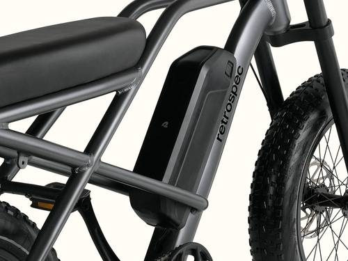 Close-up of the sleek Valen Rev 3 Fat Tire Electric Bike frame featuring a black seat, battery, and rugged tire, marked with the brand "retrospec."