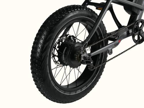 Close-up of a fat tire bicycle's rear wheel, showcasing the robust tire tread, motor, and chain details.