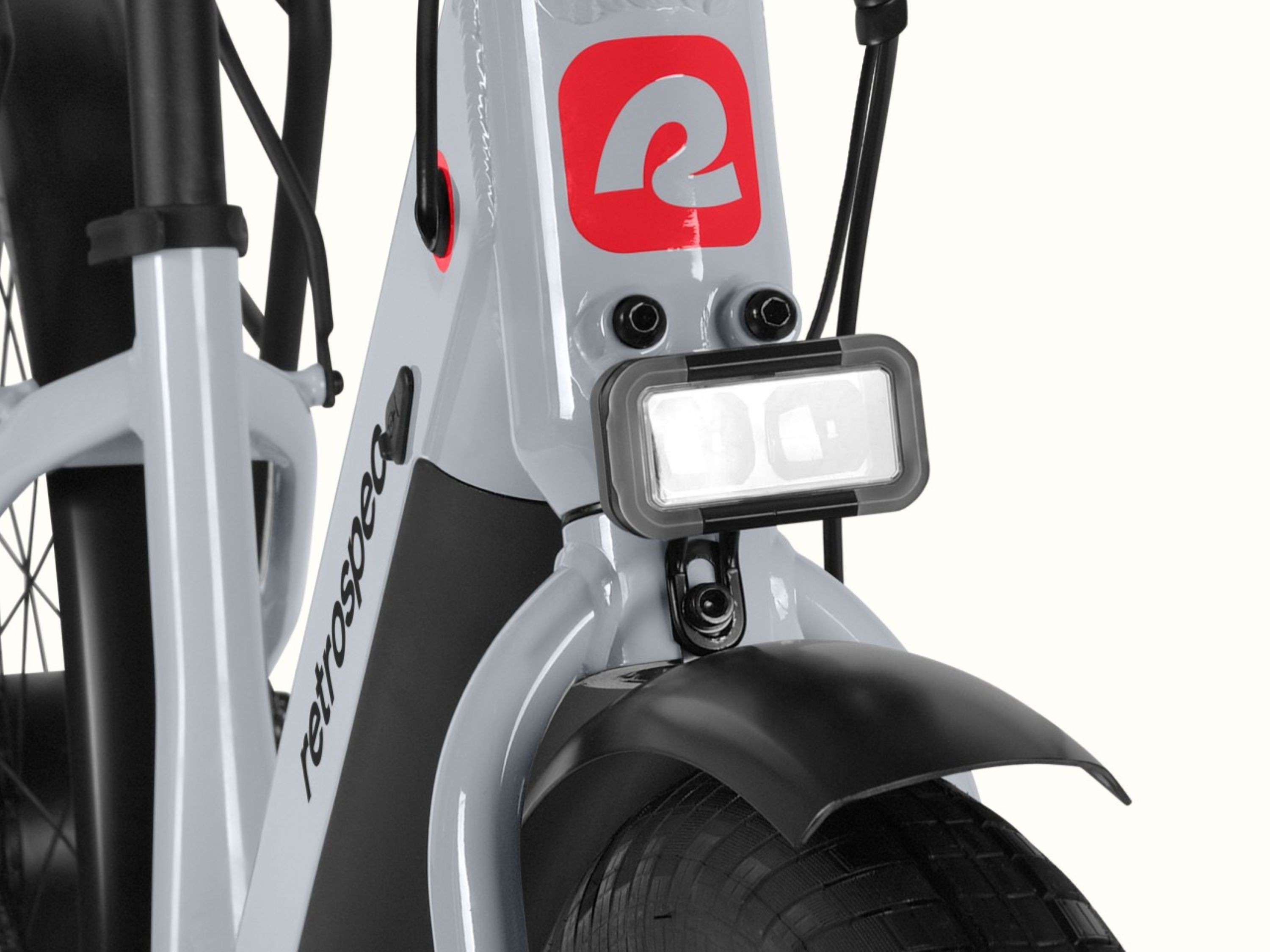 A close-up of the headlight on a gray Abbot Rev 2 Commuter Electric Bike.