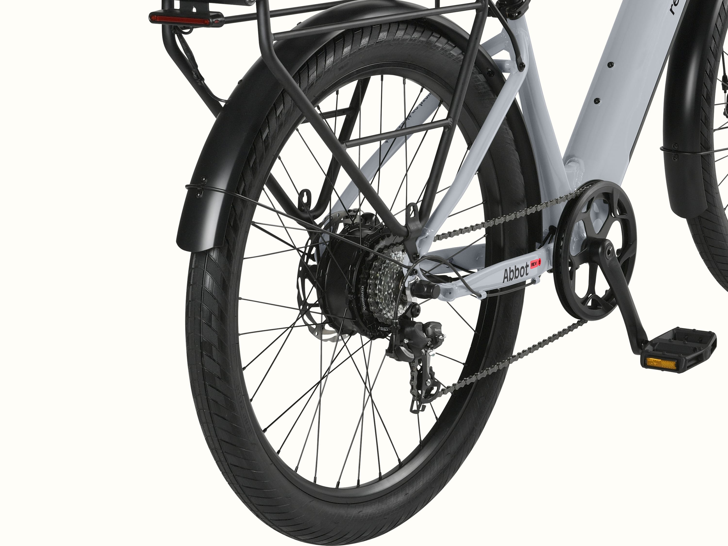 A close up the rear wheel of the gray Abbot Rev 2 EBike with a black fender and rear rack with integrated taillight.