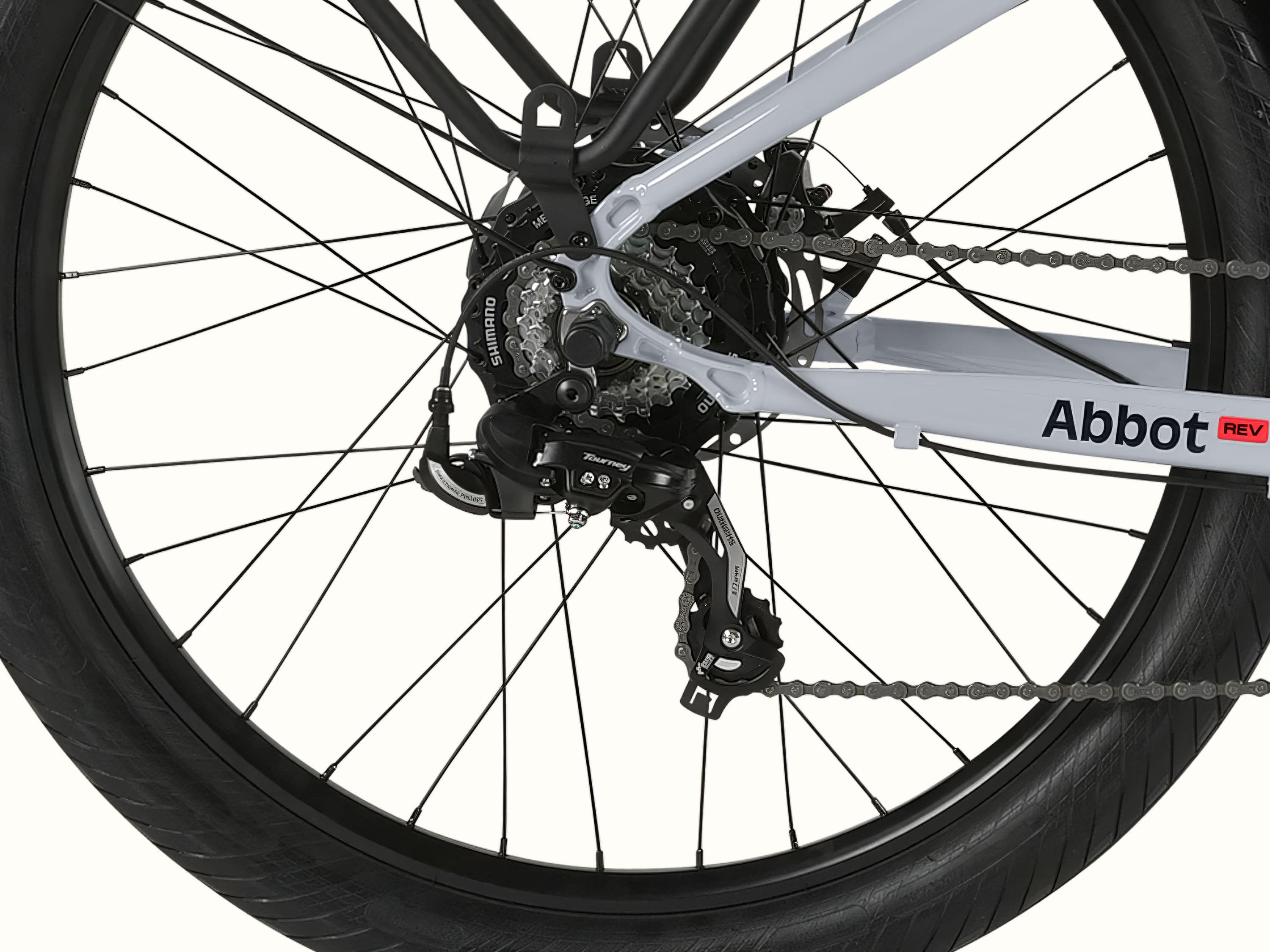 A close-up of the rear wheel of the Abbot Rev 2 EBike showcasing the Shimano 7-Speed Drivetrain with Abbot Rev logo.